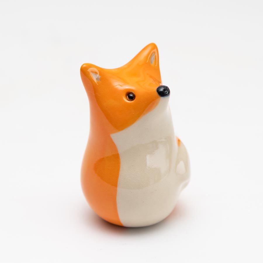 Curious Ceramic Fox Sculpture, orange and white with black eyes and nose, looking up and to the right