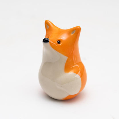 Curious Ceramic Fox Sculpture, orange and white with black nose and eyes, looking up