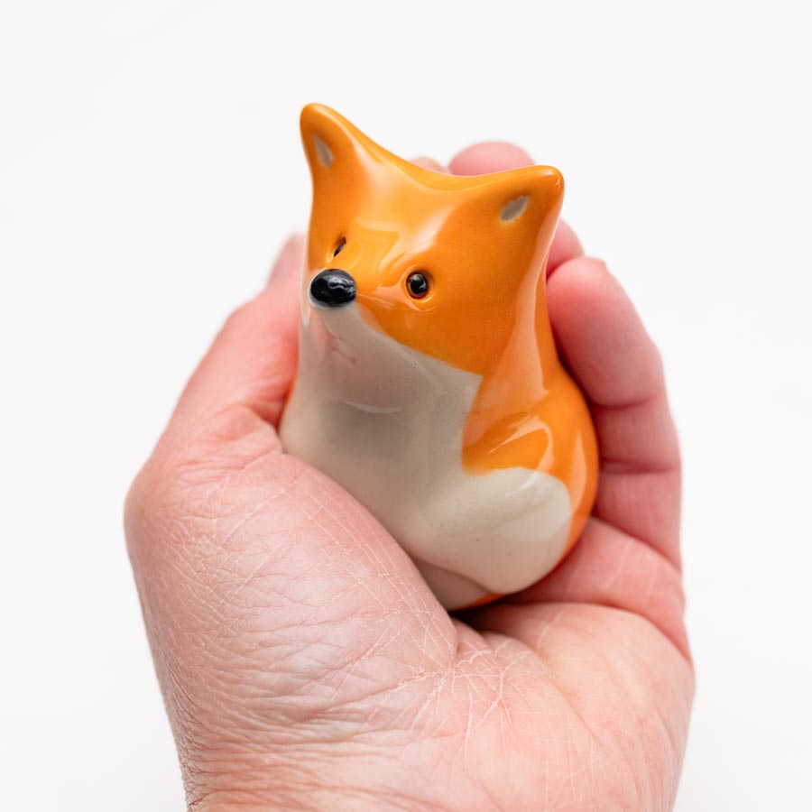 Curious Ceramic Fox Sculpture held in a person's hand