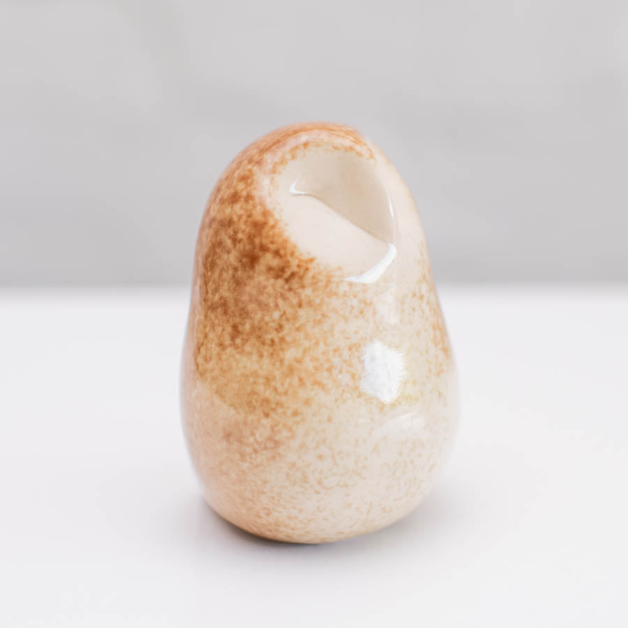 A happy little Barn Owl sculpture against  a light background
