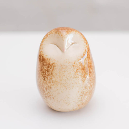 A happy little Barn Owl sculpture against  a light background