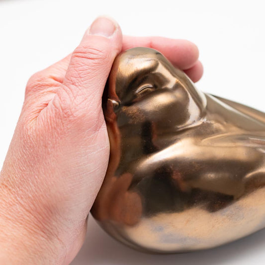 Hand holding a Medium Ceramic Gold Happy Pigeon Sculpture