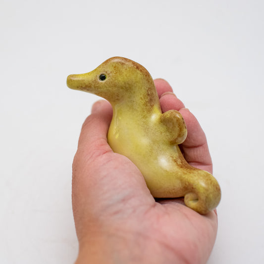 Small ceramic seahorse held in a hand