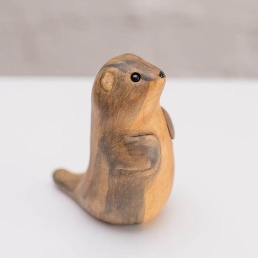A small ceramic stoat sculpture against a grey backdrop