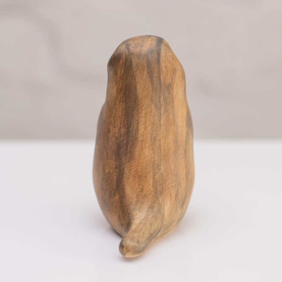 A small ceramic stoat sculpture against a grey backdrop