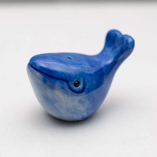 Blue ceramic whale figurine with a small black eye and a textured, lighter blue underside