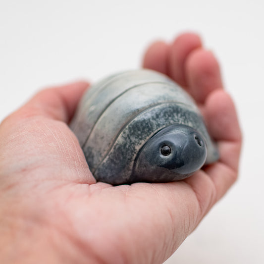 Small ceramic woodlouse held in a person's palm