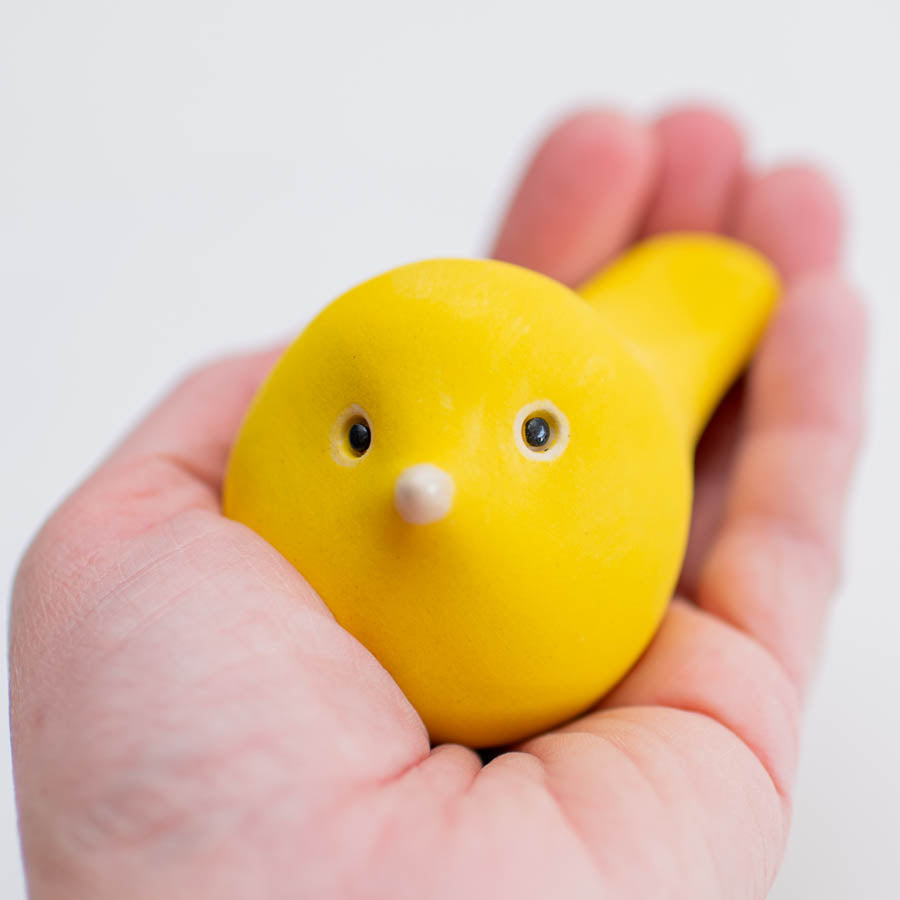 Cheerful Yellow Ceramic Bird Sculpture held in a person's palm