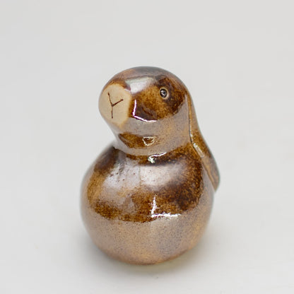 Small ceramic bunny sculpture in a brown metallic glaze