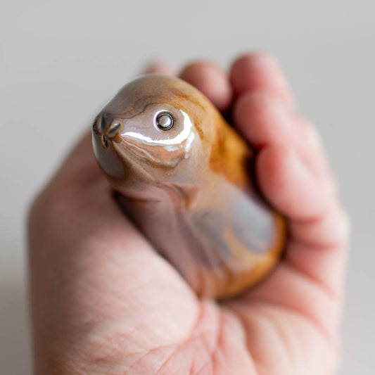 Metallic ceramic hare sculpture in a hand