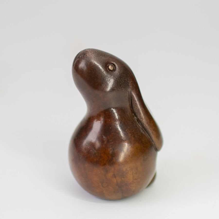 Small bronze bunny rabbit sculpture in a chocolate brown patina with shiny metallic eyes.
